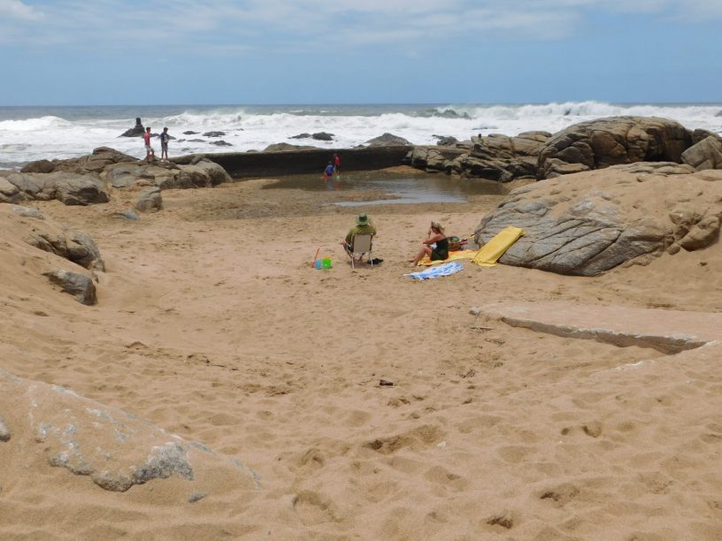 Holidaymakers camping out in the empty tidal pool